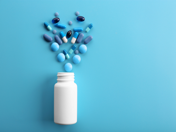 Heap of pills on blue background